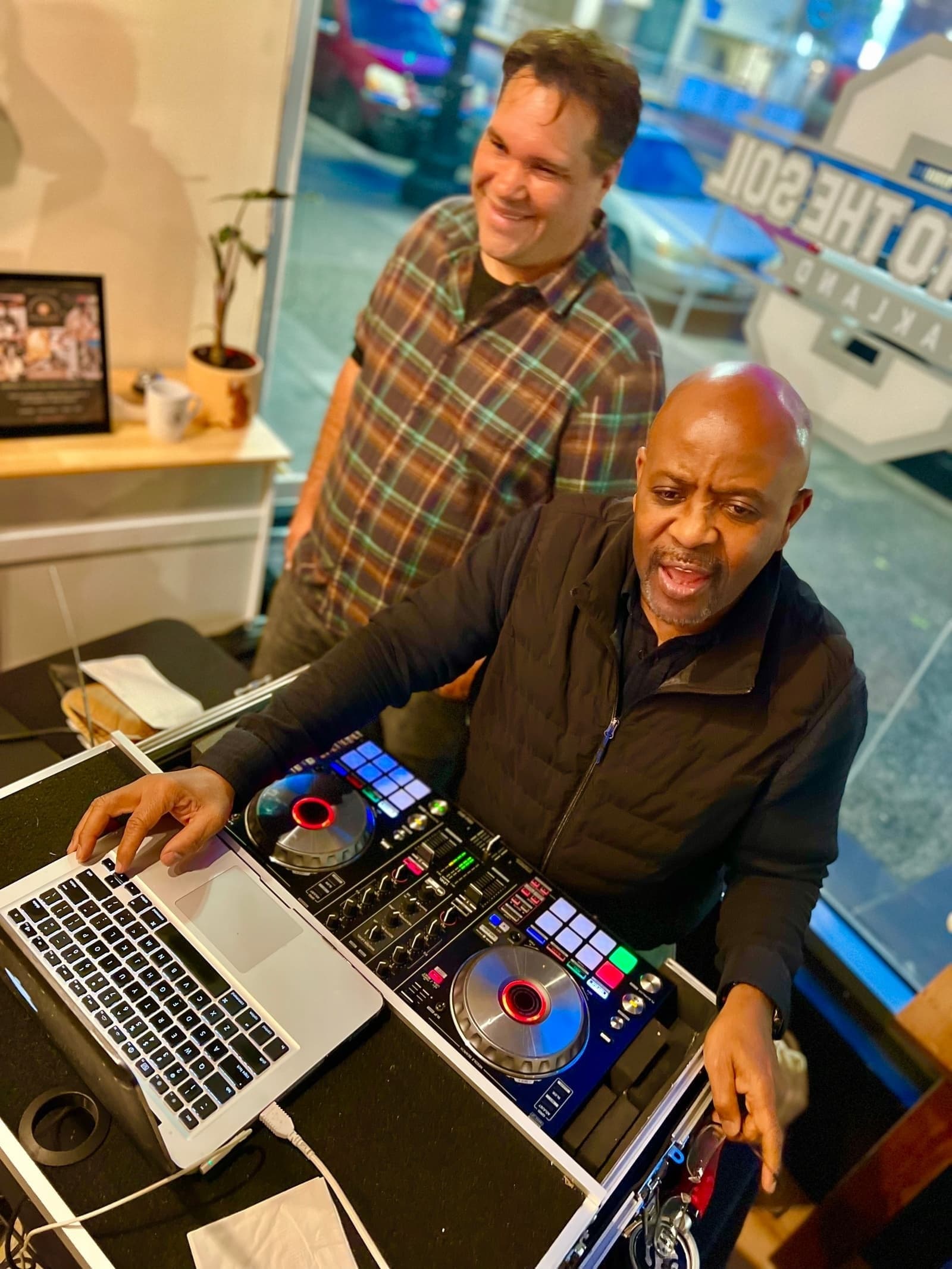 DJ Afrique working the controller with neon lighting in Oakland